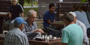 alte Männer sitzen über einem Schachbrett