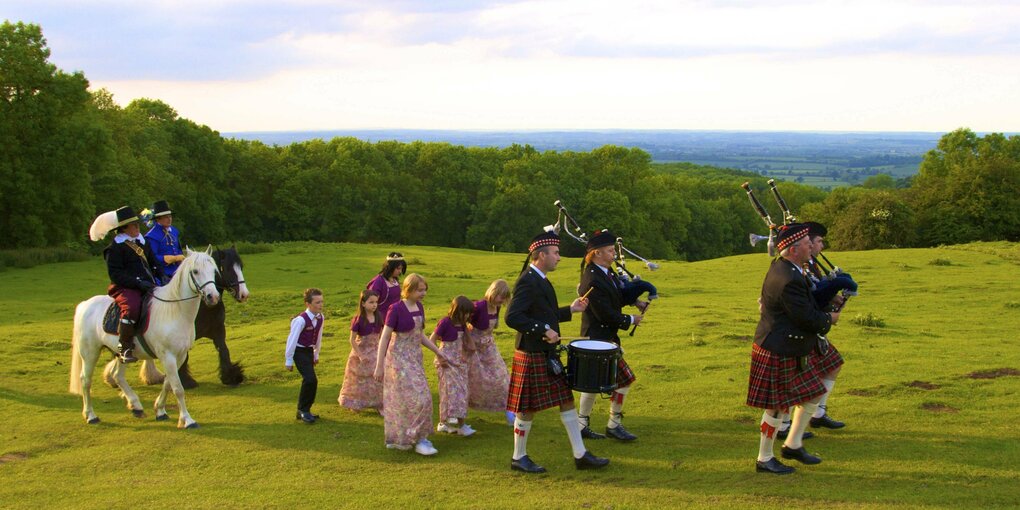 Menschen in alten Trachten mit Pferd und traditionellen Musikinstrumenten