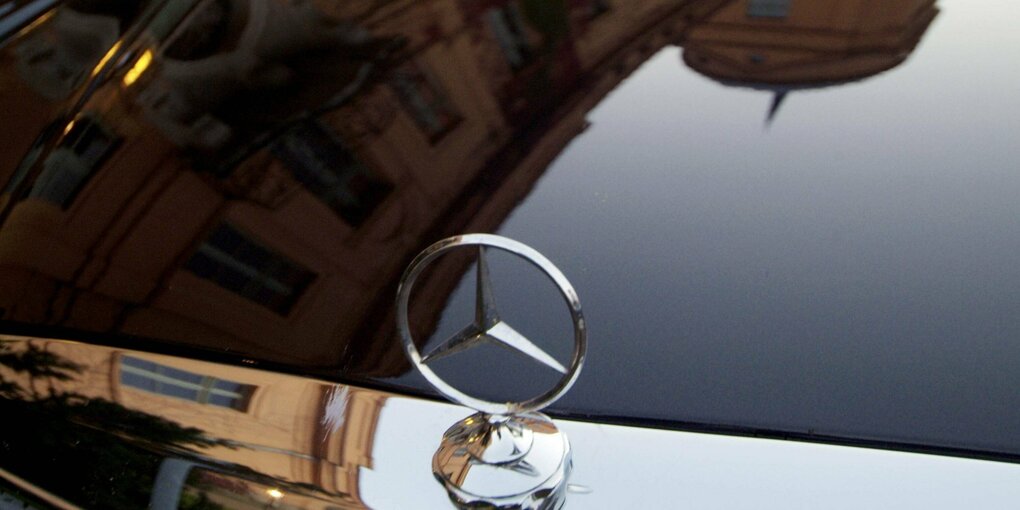 Ein Haus spiegelt sich auf einer Motorhaube mit einem Mercedesstern.