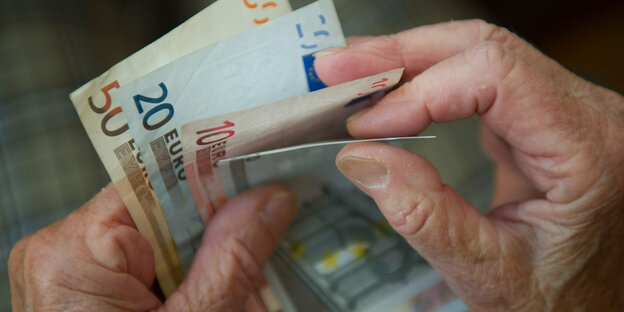 Das Bild zeigt Geldscheine in Händen mit Falten.