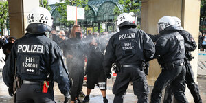 Einsatzkräfte der Polizei sprühen Reizmittel, um Teilnehmer einer aufgelösten Demonstration zurückzudrängen.