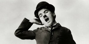 Charlie Chaplin gähnt.