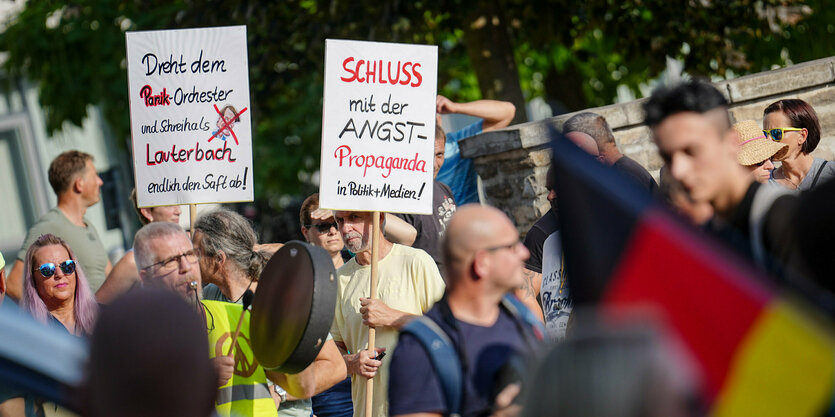 Demonstrant:innen mit Schildern und Fahnen.