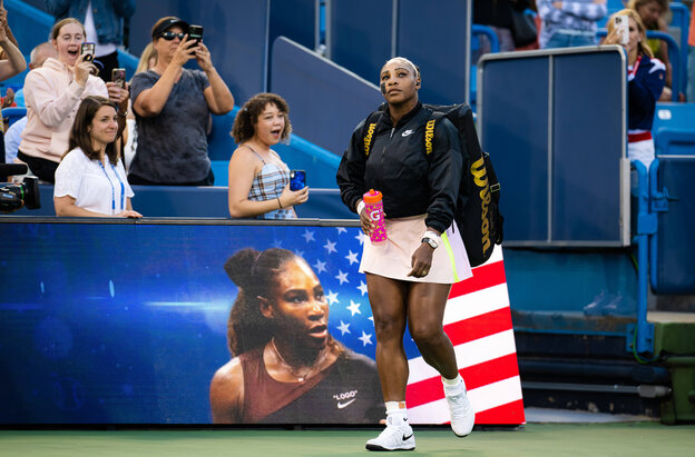 Serena Williams wird von Fans beim Betreten des Tennisplatzes fotografiert, auf der LED-Bande ist sie auch zu sehen