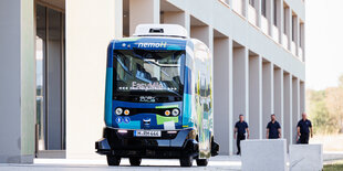 Ein elektrischer Kleinbus steht vor einem Unigebäude auf dem Maschinenbau-Campus in Garbsen bei Hannover.