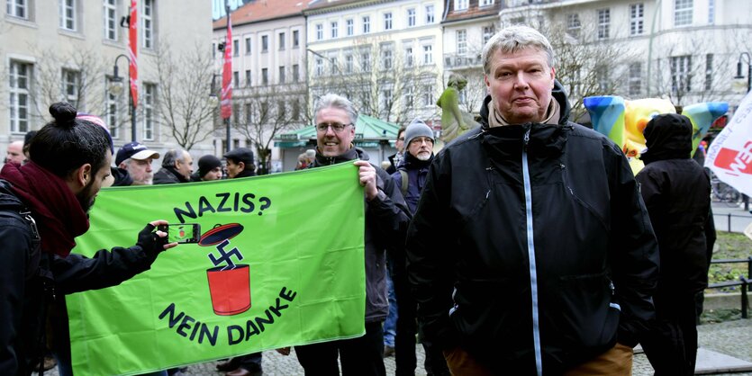 Menschen stehen um ein Transparent auf einer Demo