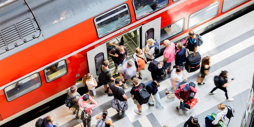 Fahrgäste steigen am Berliner Hauptbahnhof aus einem Regionalexpress aus.