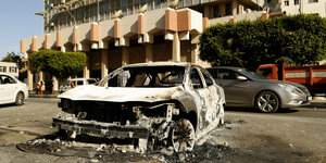 Ein ausgebranntes Auto vor einem Gebäude