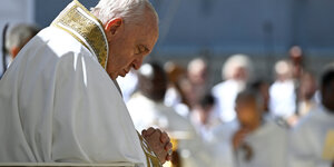 Der Papst betet vor unscharfem Hintergrund