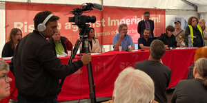 Podium auf dem UZ-Pressefest: In der Mitte sitzt DKP-Chef Patrik Köbele, links neben ihm sitzen Wolfgang Gehrcke und Sevim Dağdelen von der Linkspartei, rechts von ihm im Hintergrund steht Diether Dehm.