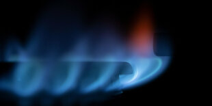 Zahlreiche blau-schimmernde Gas-Flämmchen sind an einem Gasherd zu sehen. Bundeswirtschaftsminister Habeck hat eine Änderung der geplanten Gasumlage zugesagt. Mit der Korrektur soll verhindert werden, dass von dieser Abgabe der Privathaushalte und Industrie auch Unternehmen profitieren, die dies wirtschaftlich nicht benötigen