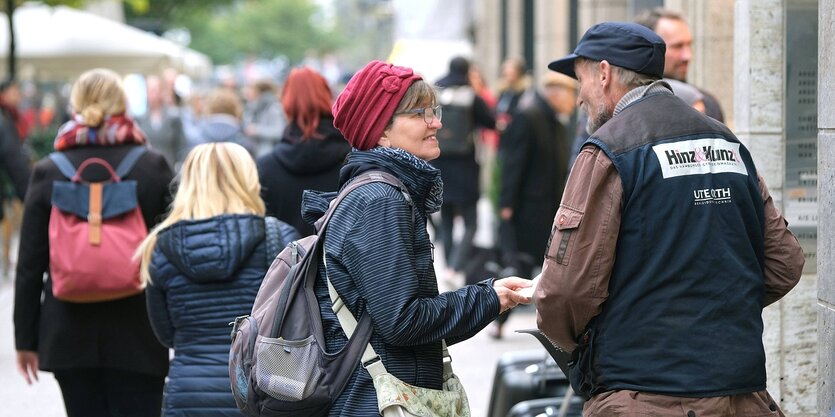 Ein Verkäufer des Strassenmagazins "Hinz&Kunzt" spricht mit einer Frau