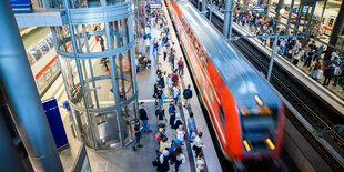 Ein Zug steht im Bahnhof, viele Menschen warten