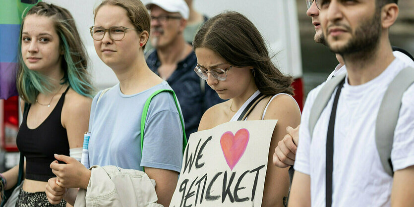 Das Bild zeigt vier junge Aktivist*innen mit Protestschild "We love 9 Euro-Ticket", mit einem roten Herz-Symbol anstelle des Worts "love".