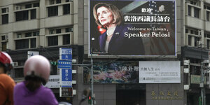 Eine große Videoleinwand an einem Wohnblock, darauf die Anzeige „Welcome to Taiwan, Speaker Pelosi“ (Willkommen in Taiwan, Sprecherin Pelosi)