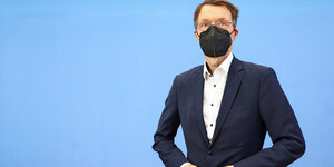 Bundesgesundheitsminister Karl Lauterbach im Anzug und mit FFP2-Maske in der Bundespressekonferenz