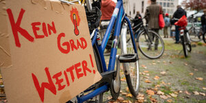 Ein Fahrrad steht vor dem Bundeskanzleramt, daran ein Schild mit der Aufschrift "Kein Grad weiter"