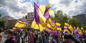 Demonstrant:innen schwenken lila-gelbe Fahnen auf einer Großdemonstration gegen Mietenwahnsinn am Nollendorfplatz