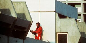 05.09.1972, Bayern, München: Ein bewaffneter Polizeibeamter im Trainingsanzug sichert am 05.09.1972 im Olympischen Dorf in München den Block, in dem Terroristen die israelischen Geiseln festhalten.