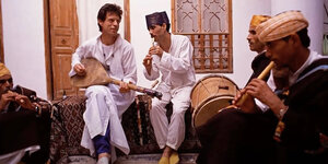 Die Musiker Bachir Attar und Mick Jagger im musikalischen Zusammenspiel in weißer Kleidung