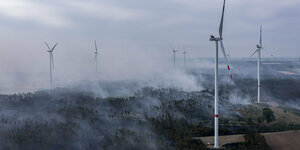 Zwischen Windkraftanlagen brennt der Wald in Brandenburg