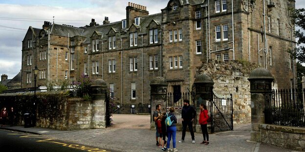 Students stand in front of the elite university of St Andrews in Scotland