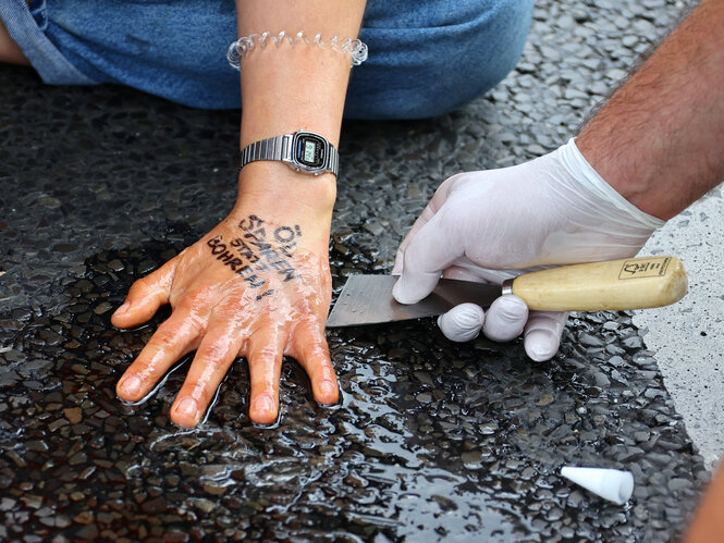 Angeklebte Hand auf dem Asphalt