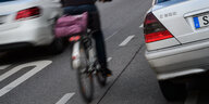 Ein Radfahrer fährt eng an einem Mercedes vorbei