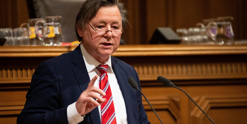 Jörn Kruse in der Hamburgischen Bürgerschaft: Ein Anzugtäger mit Lesebrille auf der Nasenspitze erhebt mahnend den Zeigefinger