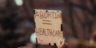 Ein Mann hält ein Schild, auf dem steht: "Abortion = Healthcare"