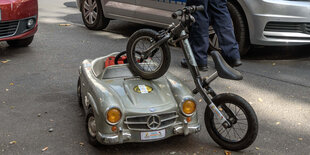 Ein Spielzeugauto und ein Kinderfahrrad