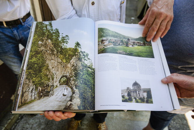 Jemand hält ein Buch mit historischen Fotos der Albtalstraße in der Hand