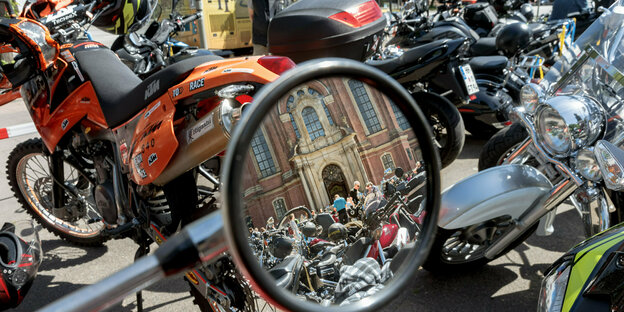 Parkende Motorräder und Blick in einen Rückspiegel