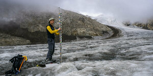 Glaziologe führt Messungen am Eis durch