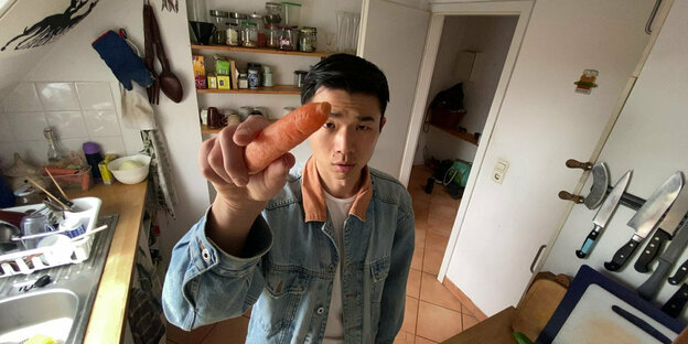 Der Videokünstler Fan Popo hält eine Karotte in die Kamera