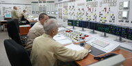 Kontrollraum eines Atomkraftwerks mit Menschen.