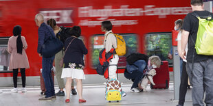 Menschen auf Bahnsteig vor Regionalexpress