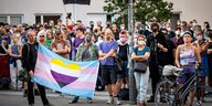 Eine Gruppe von Leuten hält ein Transparent mit einem in Trans-Farben gestreiften Herz
