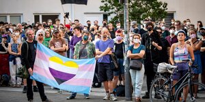 Eine Gruppe von Leuten hält ein Transparent mit einem in Trans-Farben gestreiften Herz