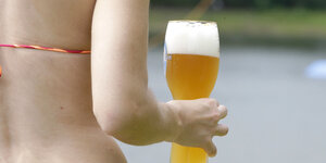 Frau von hinten mit Bierglas in der Hand