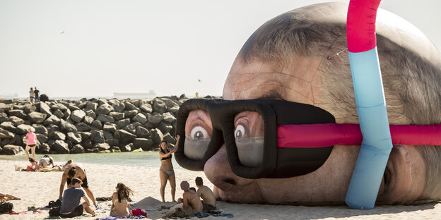 Ein überdimensionaler Kopf mit Schnorchel und Taucherbrille liegt als Skulptur am Strand Cottesloe