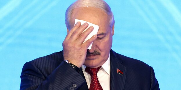 Präsident Lukaschenko wischt sich mit einem Tuch die Stirne.