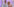 Filmstill aus "Rex Gildo – Der letzte Tanz": Conny Froboes lehnt mit dem Arm auf Rex Gildos Schulter, sie sitzen vor einem hell-lila Hintergrund und lachen