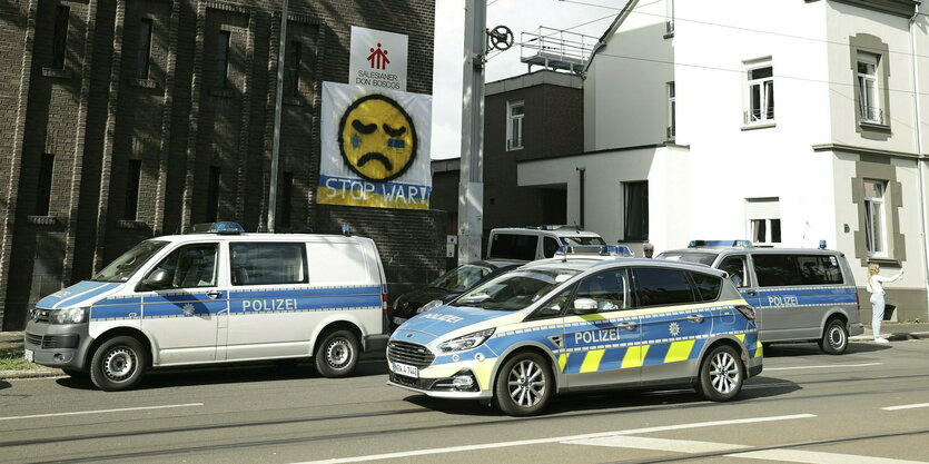 Polizeifahrzeuge stehen vor einer Schule