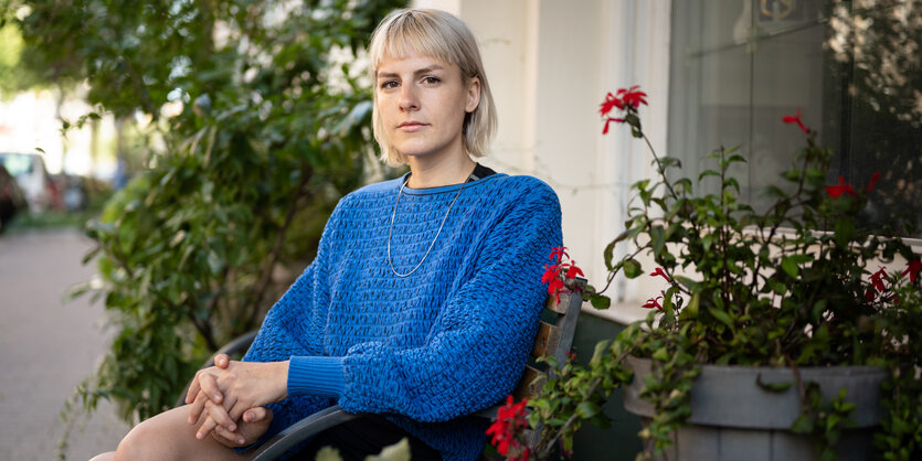 Helen Bukowski sitzt auf einer Terrasse, umgeben von Blumen