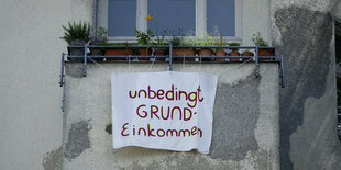 Ein Plakat an einem Balkon wirbt für ein Grundeinkommen