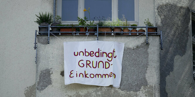 Ein Plakat an einem Balkon wirbt für ein Grundeinkommen