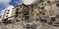 Rettungskräfte arbeiten an einem zerstörten Gebäude, dass durch einen Raketenangriff des russischen Militärs schwer beschädigt wurde