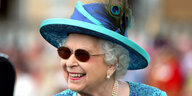 Queen Elizabeth II. mit großem blauen Hut und Sonnenbrille
