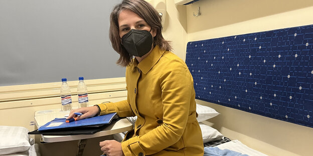 Annalena Baerbock sits on a train with an FFP2 mask